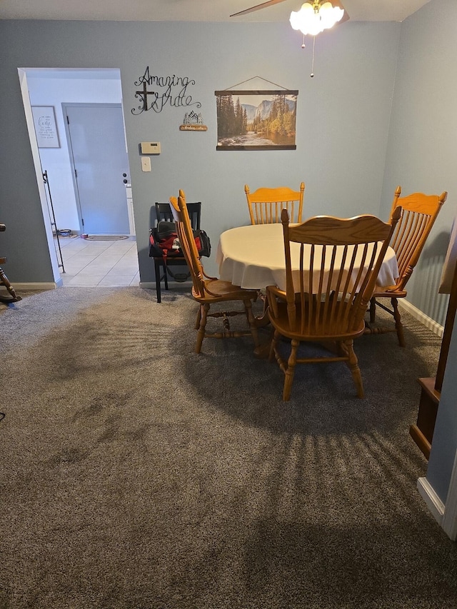 dining space featuring light colored carpet and ceiling fan