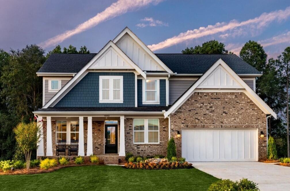 view of front of property with a yard, a garage, and a porch