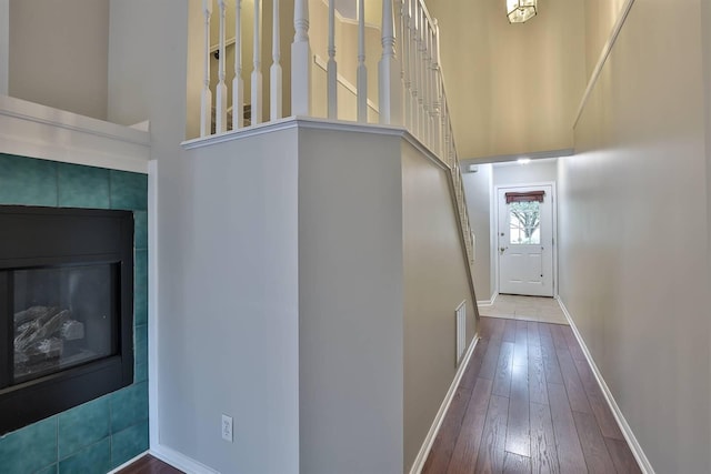 interior space featuring a high ceiling, a fireplace, and wood-type flooring