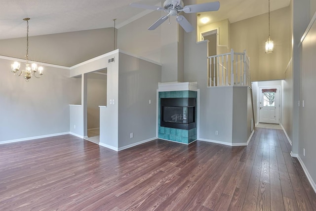 unfurnished living room featuring ceiling fan with notable chandelier, a tile fireplace, high vaulted ceiling, and hardwood / wood-style floors