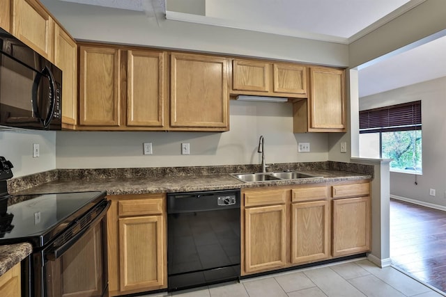 kitchen featuring black appliances, sink, and light tile patterned floors