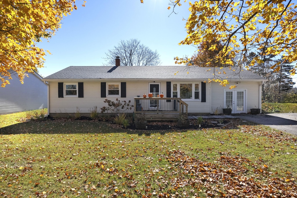 single story home with a front lawn, french doors, and a wooden deck