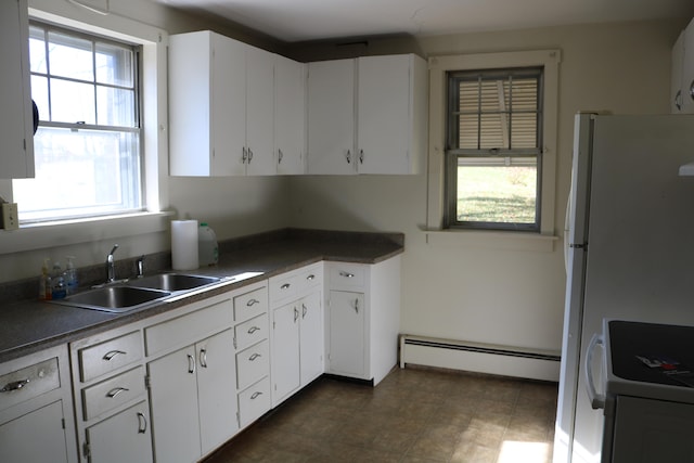 kitchen featuring white cabinetry, sink, and a baseboard heating unit