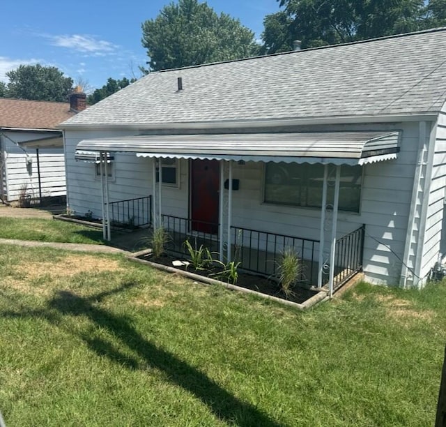 rear view of house featuring a yard