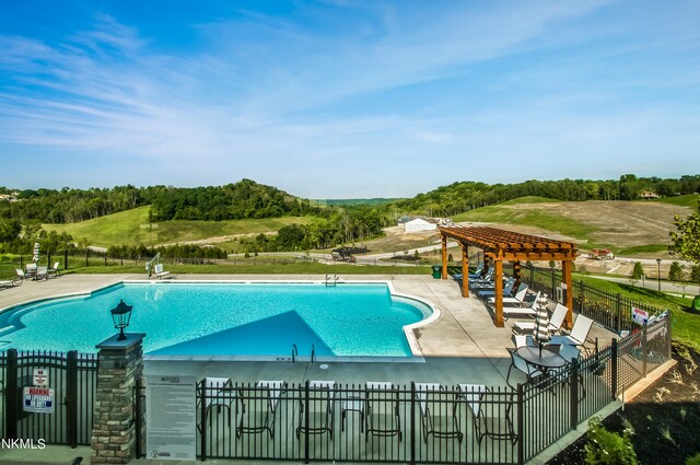 community pool with a patio area, fence, and a pergola