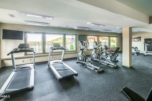 exercise room with visible vents, plenty of natural light, and baseboards