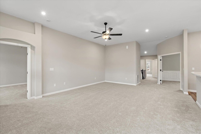 spare room with baseboards, arched walkways, light colored carpet, ceiling fan, and recessed lighting