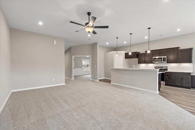 kitchen featuring open floor plan, light countertops, appliances with stainless steel finishes, and a kitchen island