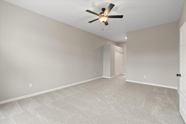 unfurnished room featuring light carpet, ceiling fan, and baseboards