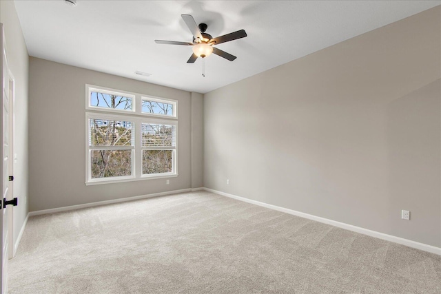 spare room featuring baseboards, visible vents, ceiling fan, and light colored carpet