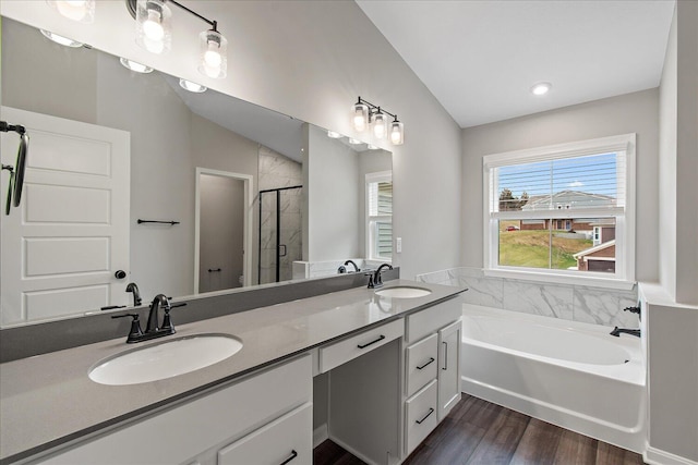 bathroom with vaulted ceiling, a garden tub, a sink, and a shower stall