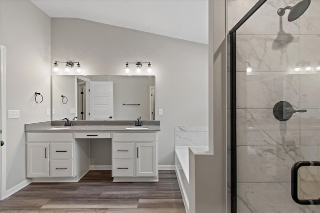 full bathroom featuring vaulted ceiling, double vanity, a sink, and wood finished floors