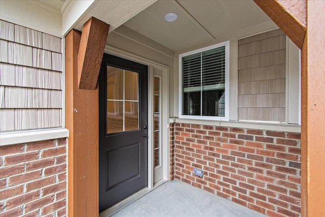 doorway to property featuring brick siding