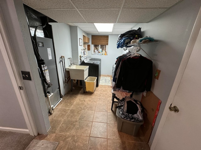 clothes washing area featuring sink, light tile patterned flooring, and washer and dryer