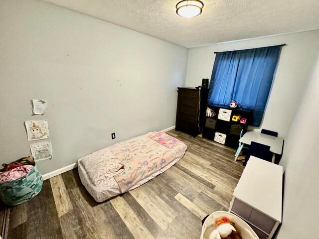 bedroom with hardwood / wood-style flooring and a textured ceiling