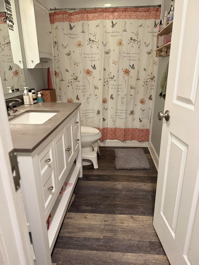 full bathroom featuring hardwood / wood-style floors, vanity, toilet, and shower / bathtub combination with curtain