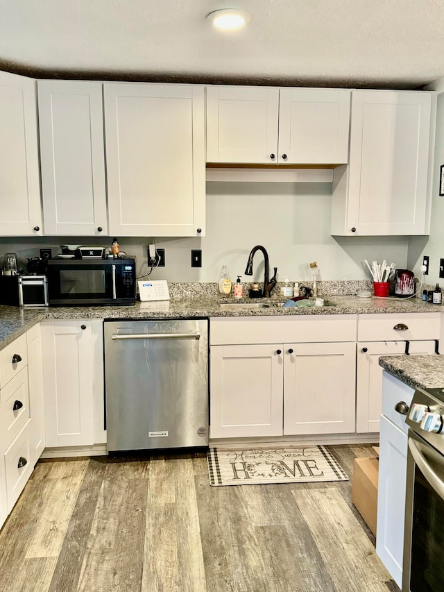 kitchen with white cabinetry, sink, stainless steel appliances, and light wood-type flooring