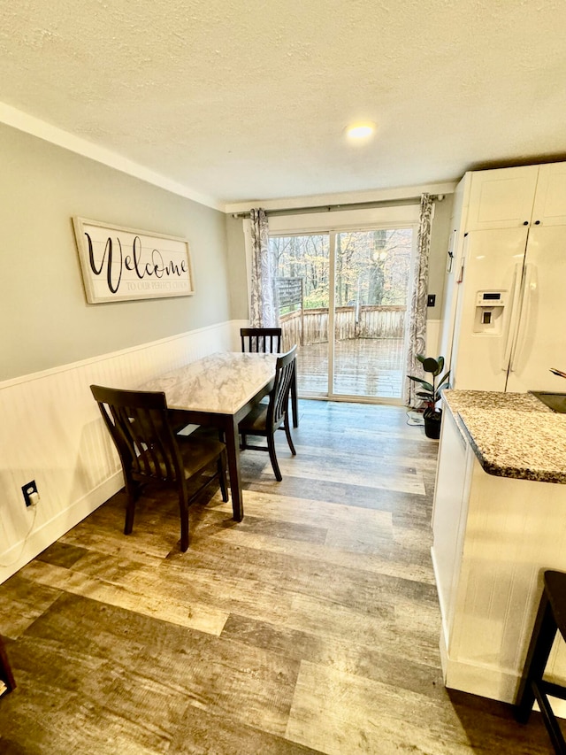 dining area with hardwood / wood-style flooring and a textured ceiling