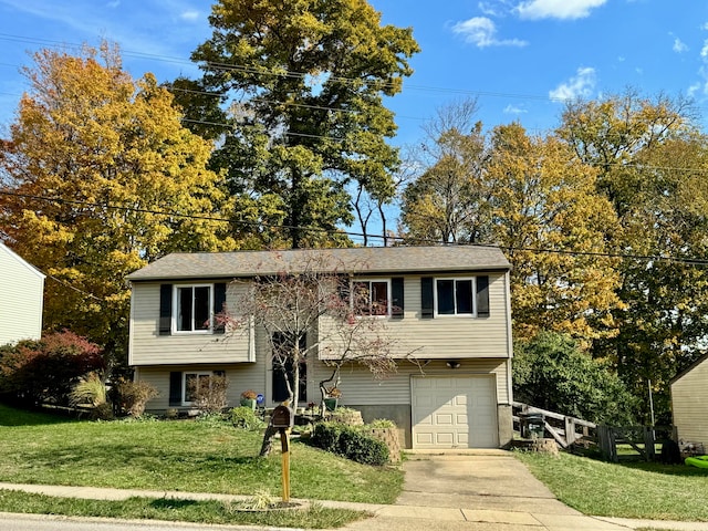 raised ranch with a front lawn and a garage