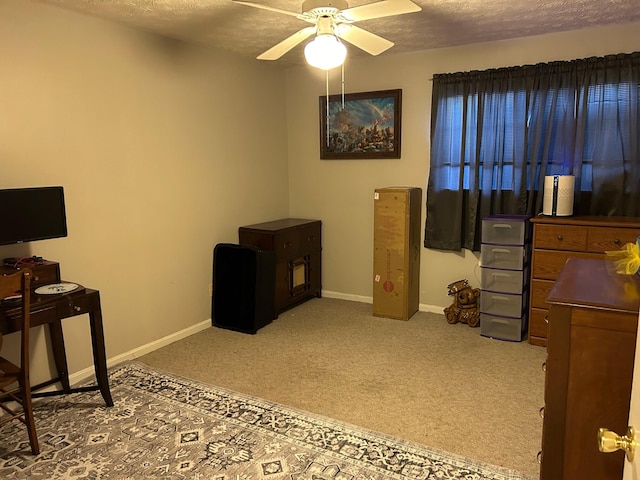 home office with ceiling fan, a textured ceiling, and carpet