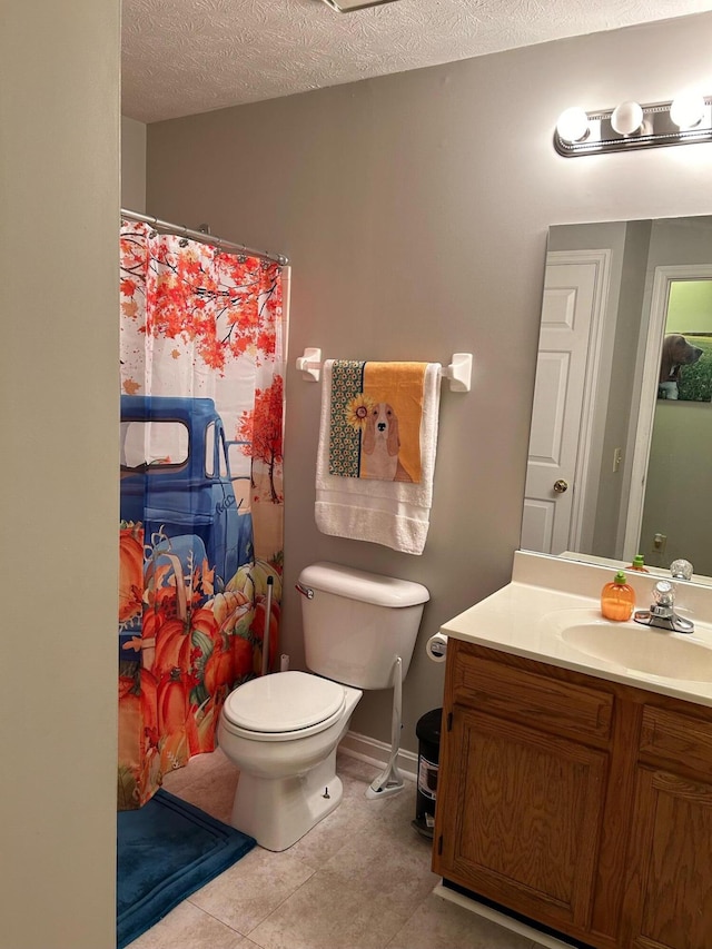 bathroom with toilet, vanity, a textured ceiling, and tile patterned flooring