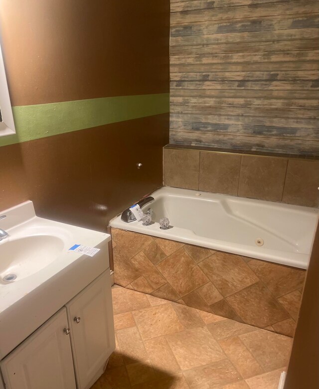 bathroom with vanity and tiled tub