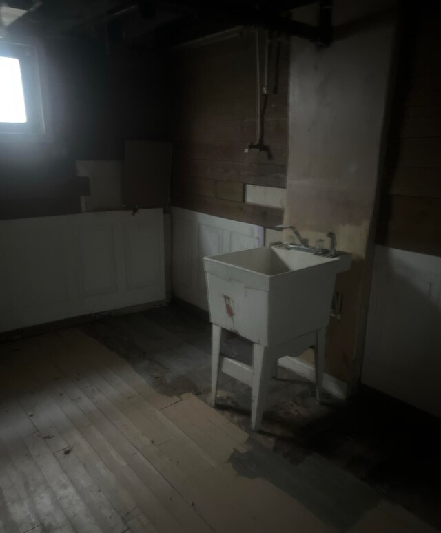 basement featuring sink and light hardwood / wood-style flooring