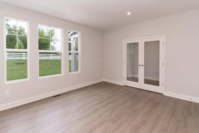 spare room featuring hardwood / wood-style flooring and french doors