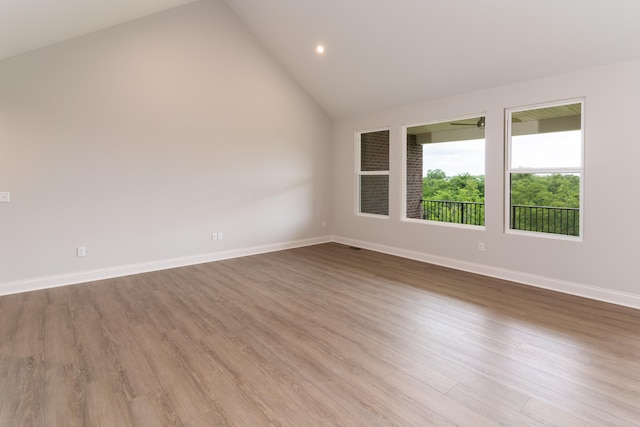 unfurnished room with high vaulted ceiling and light hardwood / wood-style flooring