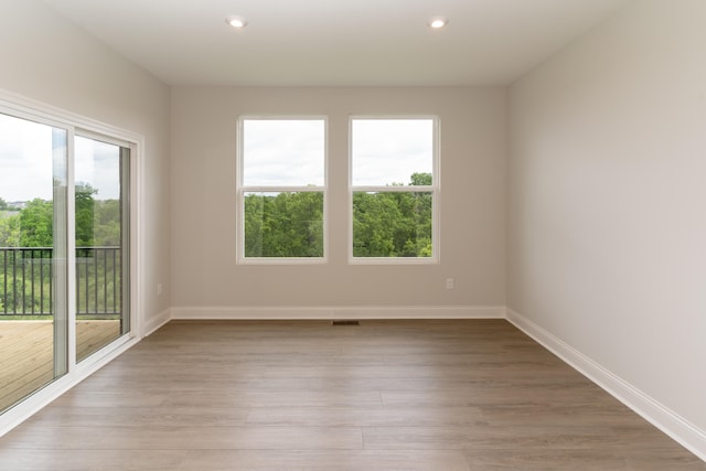 empty room featuring light wood-type flooring and a healthy amount of sunlight