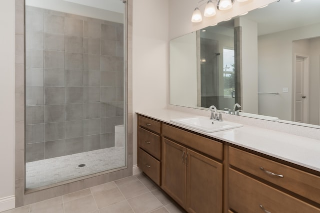 bathroom featuring vanity, tile patterned flooring, and a tile shower