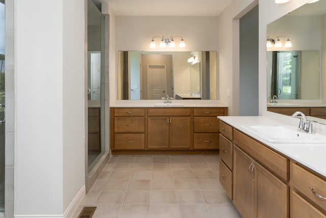 bathroom with walk in shower, vanity, and tile patterned flooring