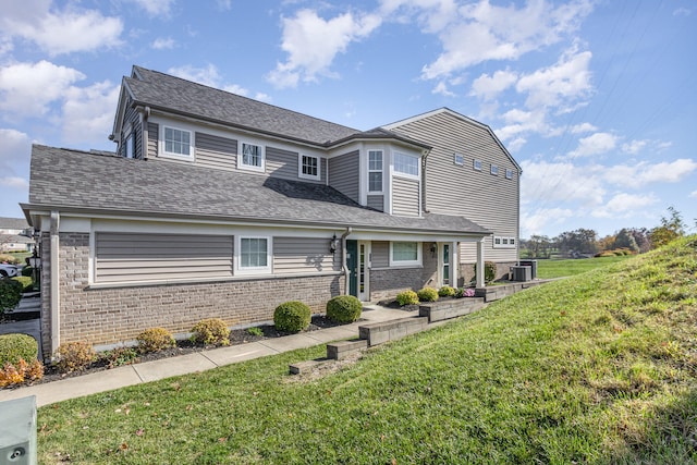 view of front of house featuring central AC unit and a front lawn