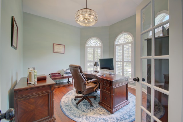 office area featuring an inviting chandelier, light hardwood / wood-style flooring, and french doors