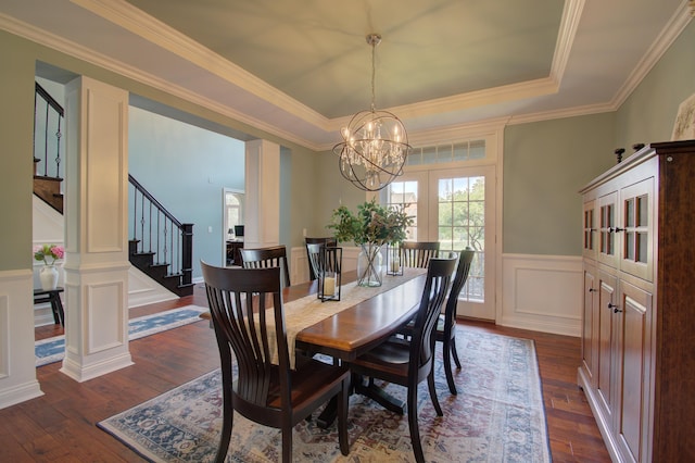 dining space with a raised ceiling, dark hardwood / wood-style floors, and an inviting chandelier