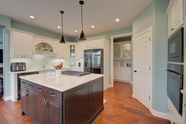 kitchen with sink, decorative light fixtures, black appliances, dark brown cabinets, and white cabinets