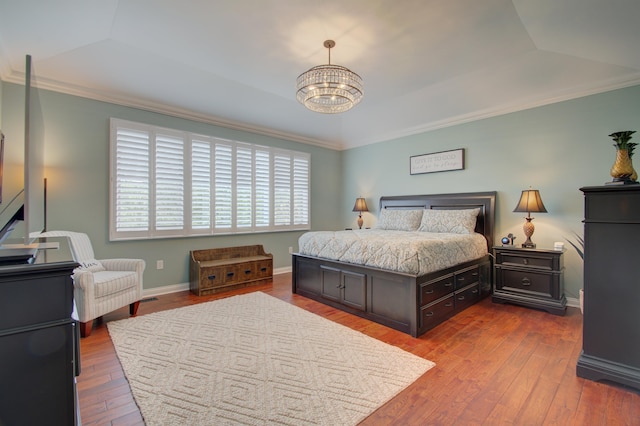 bedroom with a raised ceiling, vaulted ceiling, and hardwood / wood-style floors