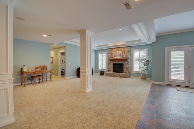 living room with crown molding, a stone fireplace, carpet floors, and ornate columns