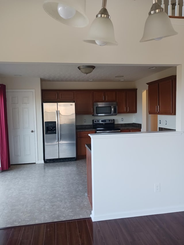 kitchen featuring appliances with stainless steel finishes, dark hardwood / wood-style floors, and decorative light fixtures