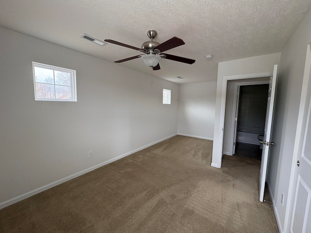 carpeted spare room with a textured ceiling and ceiling fan