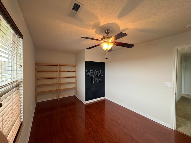 unfurnished bedroom featuring a textured ceiling, dark hardwood / wood-style floors, and ceiling fan