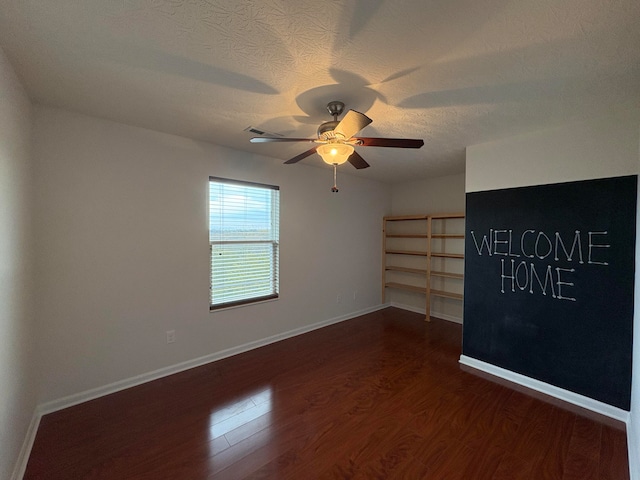 unfurnished room with dark hardwood / wood-style flooring, a textured ceiling, and ceiling fan