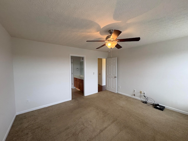 unfurnished bedroom with a textured ceiling, dark colored carpet, ceiling fan, and ensuite bathroom