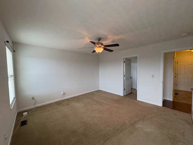 unfurnished bedroom with a textured ceiling, carpet flooring, and ceiling fan