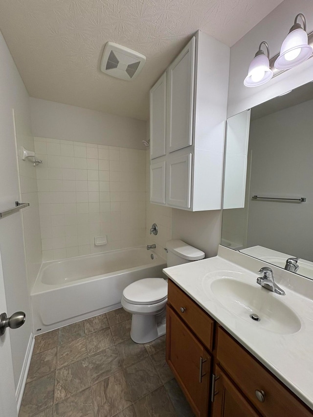 full bathroom with vanity, a textured ceiling, toilet, and tiled shower / bath