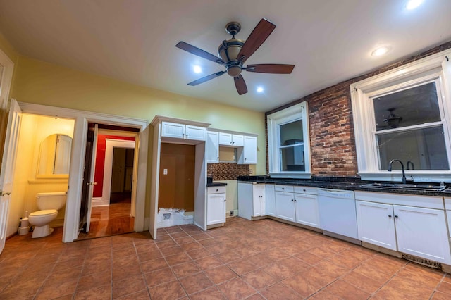 kitchen featuring backsplash, white dishwasher, sink, white cabinets, and ceiling fan