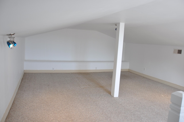 bonus room featuring lofted ceiling and light carpet