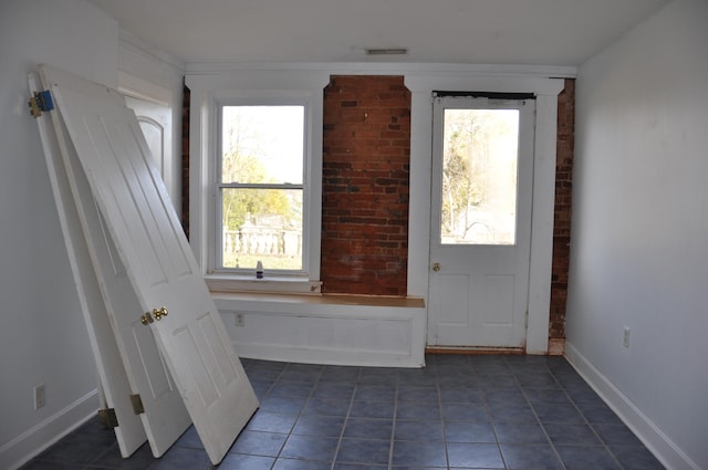 entryway featuring a healthy amount of sunlight and dark tile patterned flooring