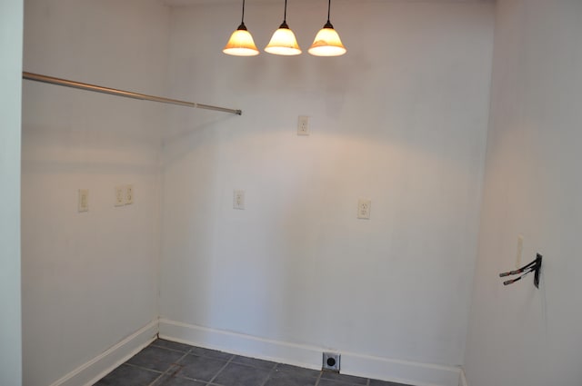 laundry area featuring dark tile patterned flooring and electric dryer hookup