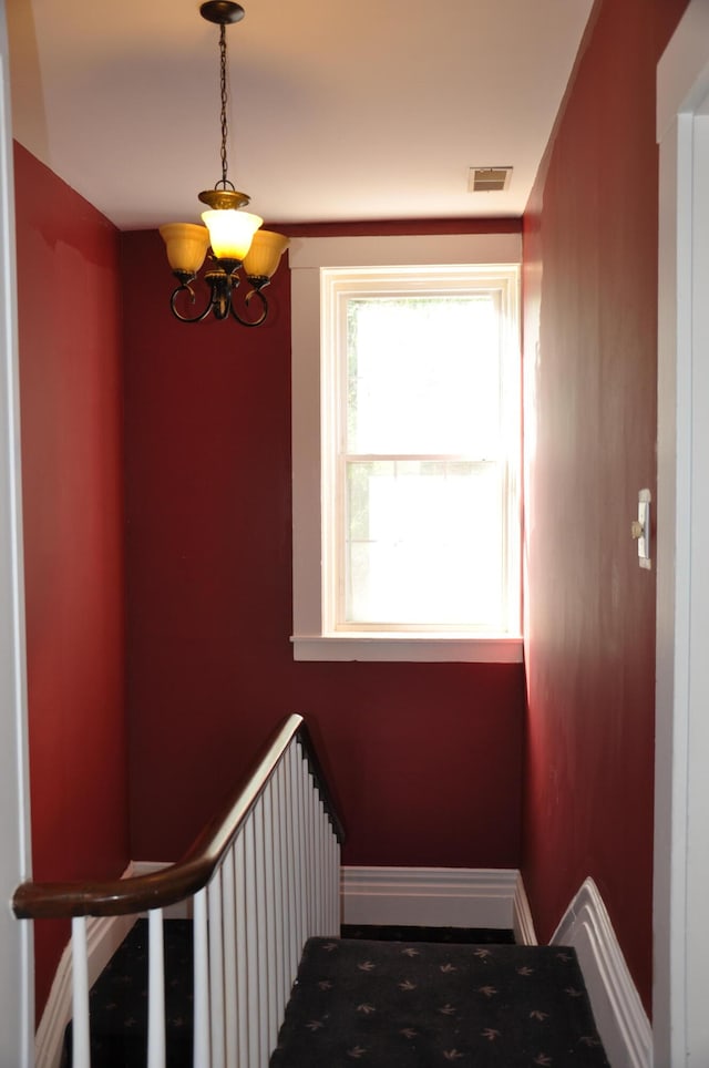 staircase featuring a notable chandelier